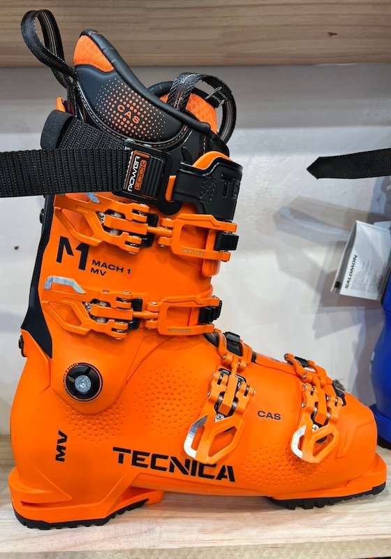 Tecnica Mach 1 MV ski boots in orange. These boots are designed for expert skiers and offer high performance features.