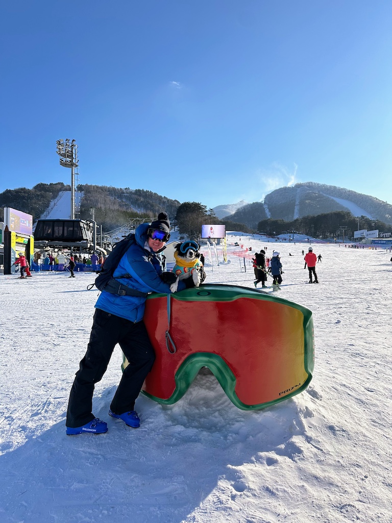 A skier and his dog pose outside of Dragon Plaza at the base area of Yongpyong Resort in South Korea. 