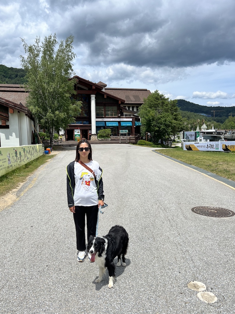 A tourist and her dog stand outside of Dragon Plaza at Yongpyong Resort during the summer season. 