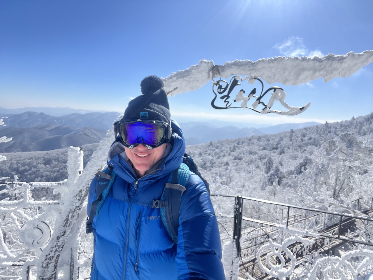 Skier sitting inside Dragon Castle at Yongpyong Resort in front of a menu sign displaying various Korean food options.