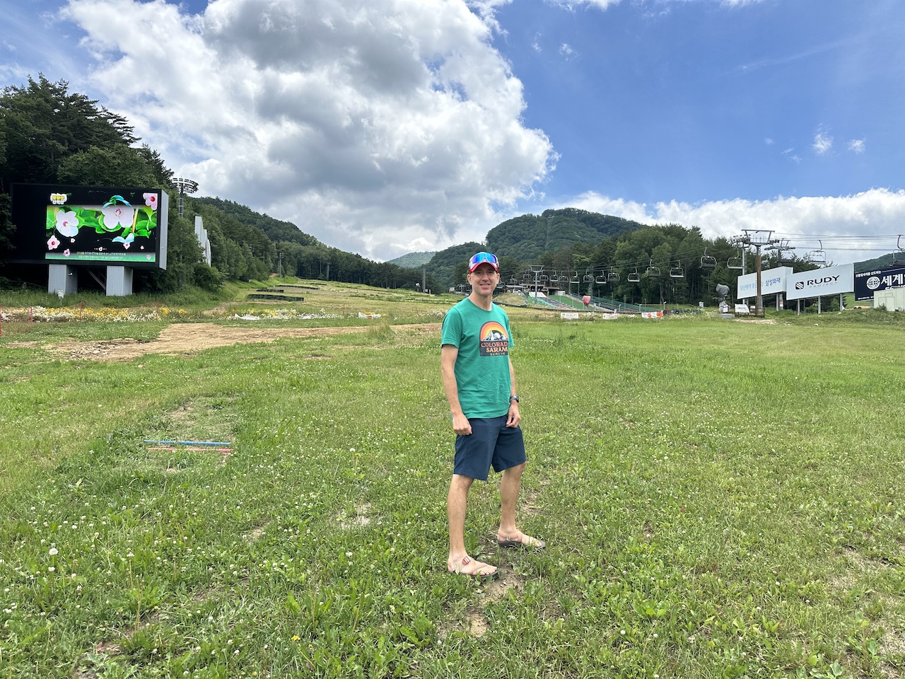 A tourist stands on the grass of a ski trail during summer at the base of Mona Yongpyong Resort in South Korea.