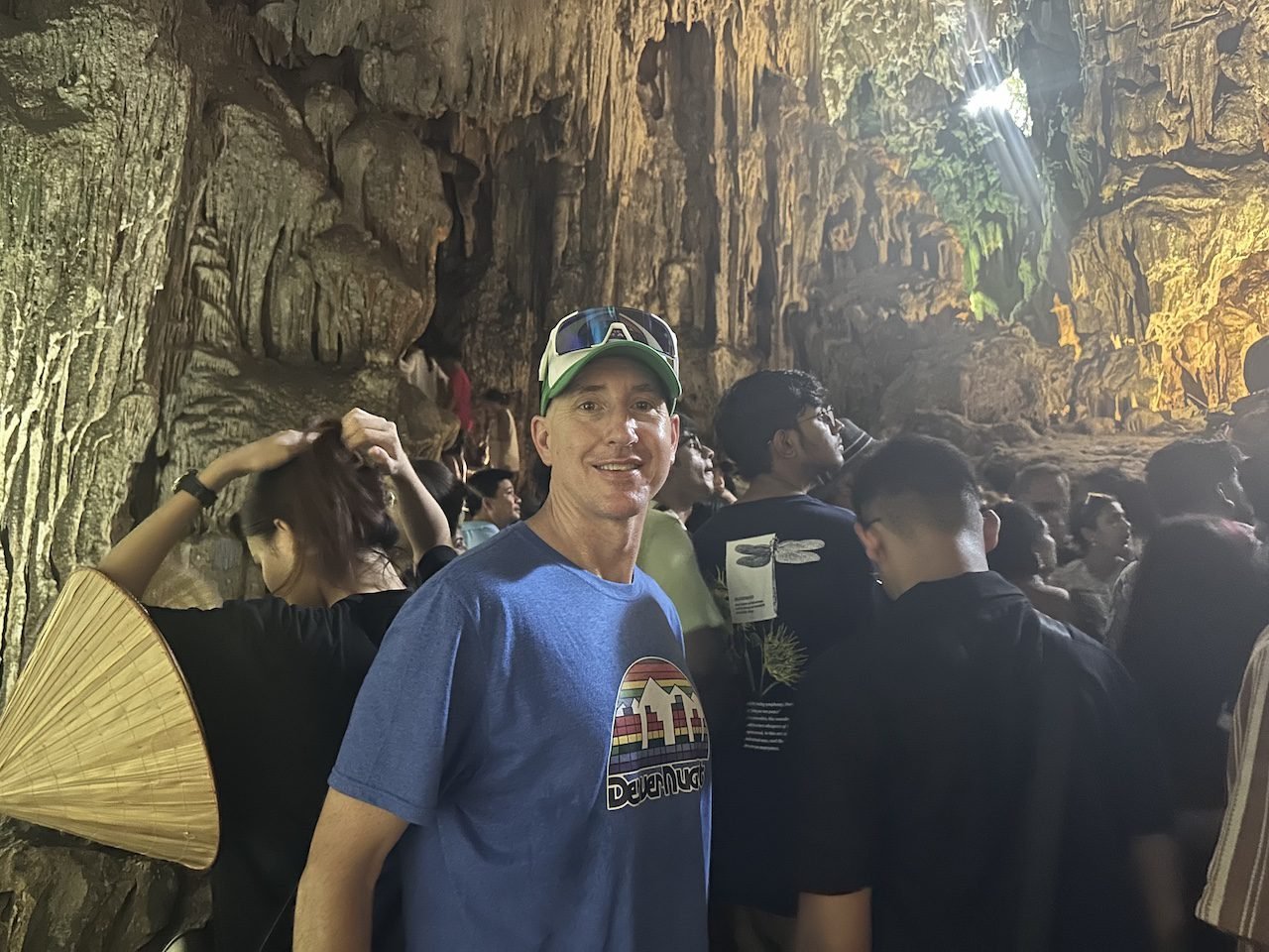 A crowded cave in Ha Long Bay, Vietnam, with tourists exploring the limestone formations during a guided tour in summer 2024.