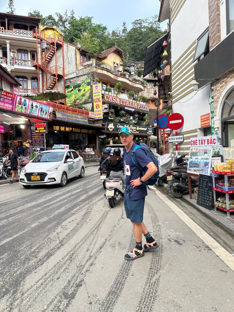 A traveler in Sapa Town, Vietnam, surrounded by bustling streets, local shops, and outdoor gear stores.