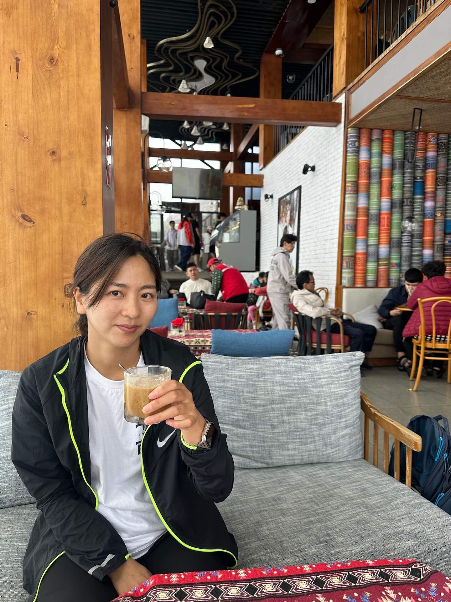 A woman enjoying a cup of coffee at the highest cafe on Fansipan Mountain in Sapa, Vietnam.