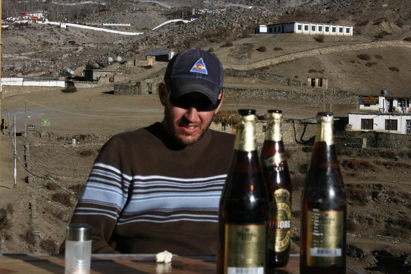 Annapurna Circuit vs Everest Base Camp: How to Choose the Right Nepal Trek 11 Trekker enjoying a Tuborg beer at a high-elevation teahouse on the Annapurna Circuit, Nepal