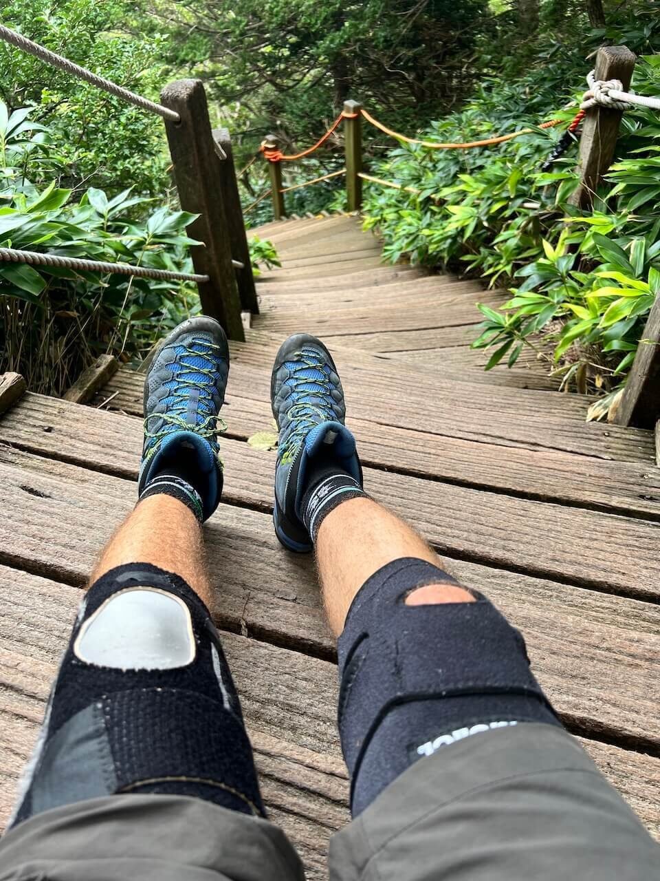 Why Climbing Hallasan in Summer Nearly Broke Me (And What I’d Do Differently) 3 Hiker sitting with knee braces on steep wooden stairs of Hallasan’s Gwaneumsa Trail