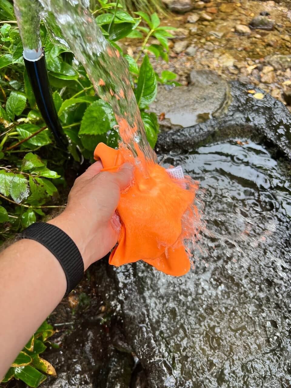 Why Climbing Hallasan in Summer Nearly Broke Me (And What I’d Do Differently) 15 Hiker rinsing towel under natural spring water on Hallasan trail