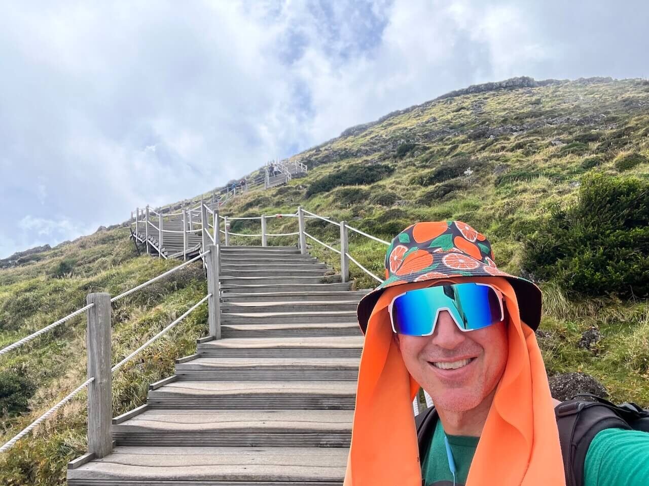 Why Climbing Hallasan in Summer Nearly Broke Me (And What I’d Do Differently) 16 Hiker wearing bright sun protection at the final stair section near Hallasan’s summit on the Seongpanak Trail