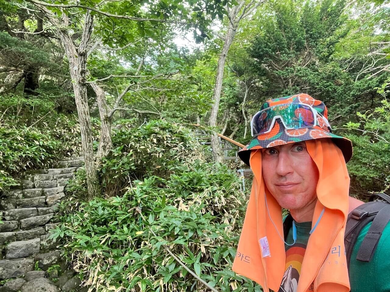 Why Climbing Hallasan in Summer Nearly Broke Me (And What I’d Do Differently) 2 Sweaty hiker wearing a towel and sun hat while climbing Hallasan in summer heat