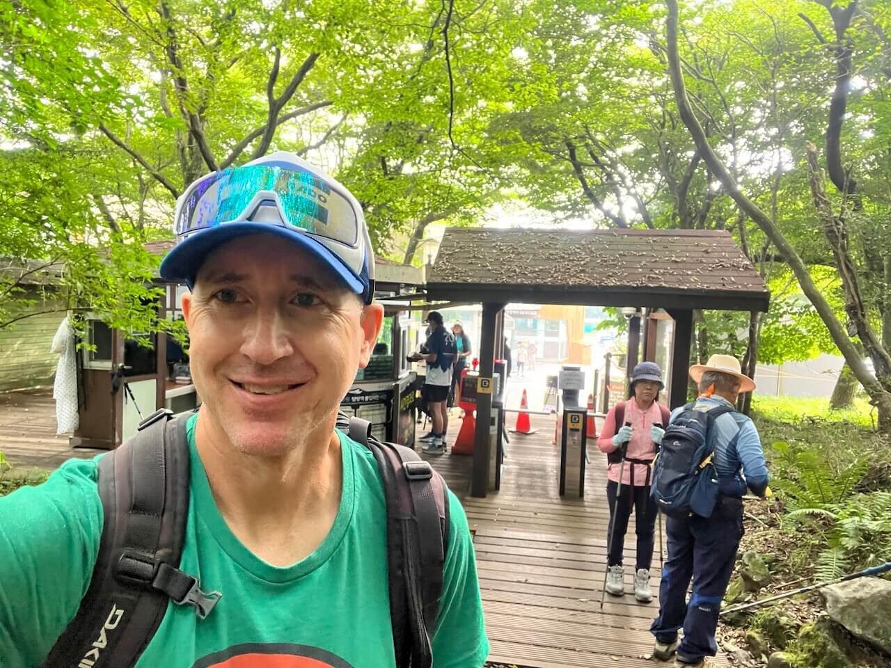 Why Climbing Hallasan in Summer Nearly Broke Me (And What I’d Do Differently) 11 Hiker entering Seongpanak trail gate on Hallasan, surrounded by Korean hikers in full trekking gear