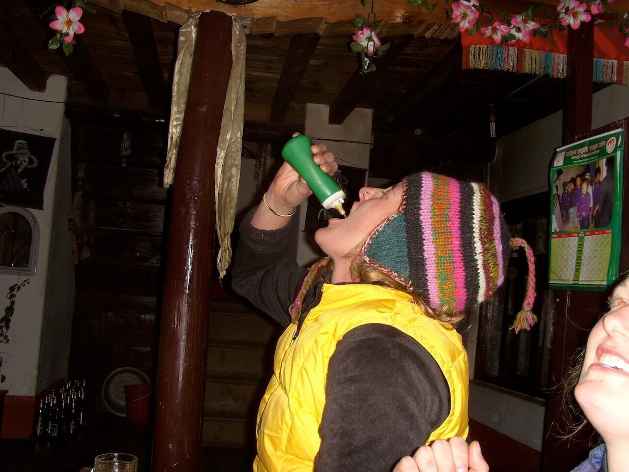 Annapurna Circuit vs Everest Base Camp: How to Choose the Right Nepal Trek 14 Female trekker taking a chili sauce shot inside a teahouse at Muktinath after crossing Thorong La Pass