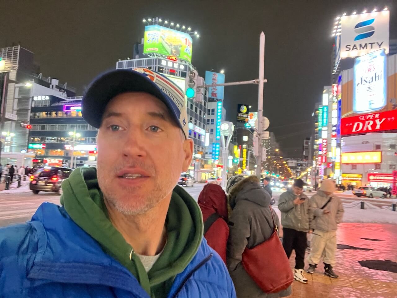 A man stands in the Susukino District of Sapporo on a winter night. 