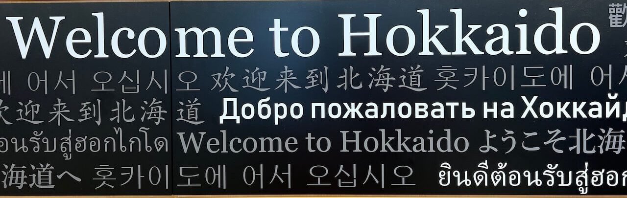 The Perfect 5–7 Day Hokkaido Ski Itinerary (2025 Guide) 5 Multilingual “Welcome to Hokkaido” sign at New Chitose Airport arrival area in Japan