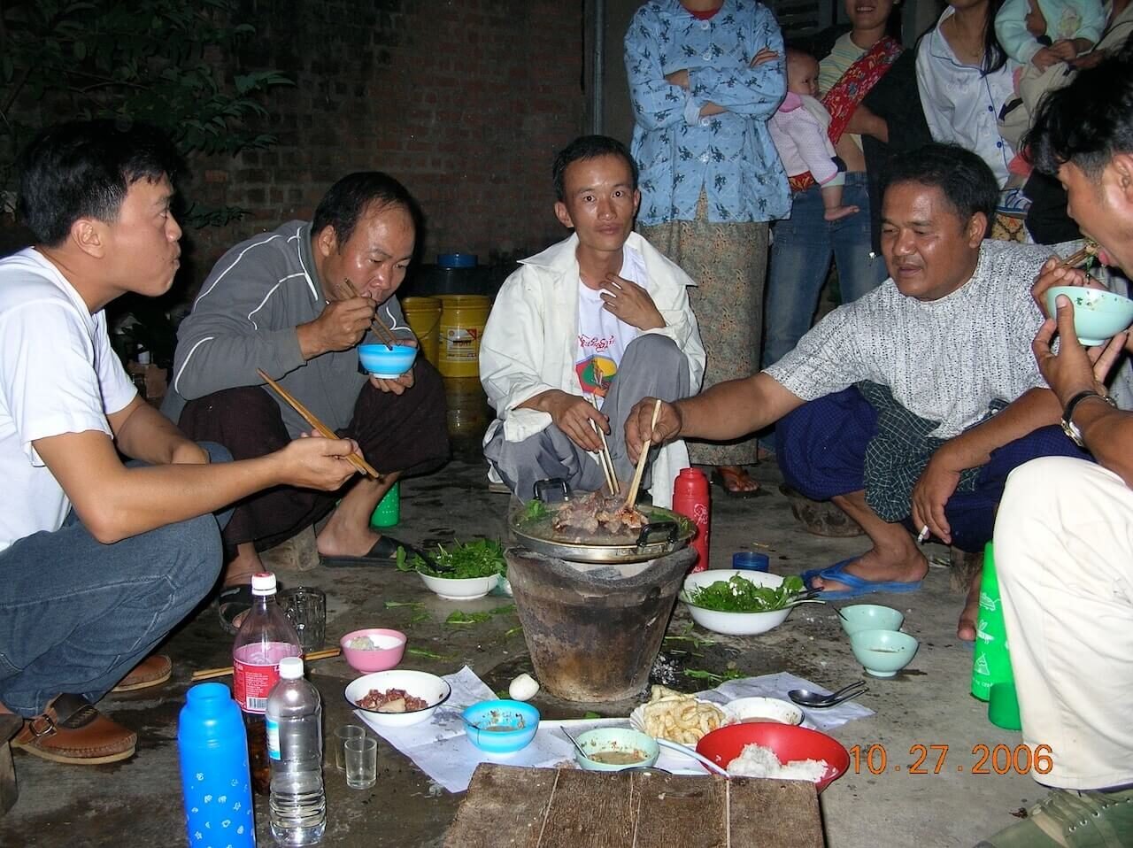 The author sharing a home-cooked meal with his guide’s family near Kengtung, Myanmar, during an overnight village stay.