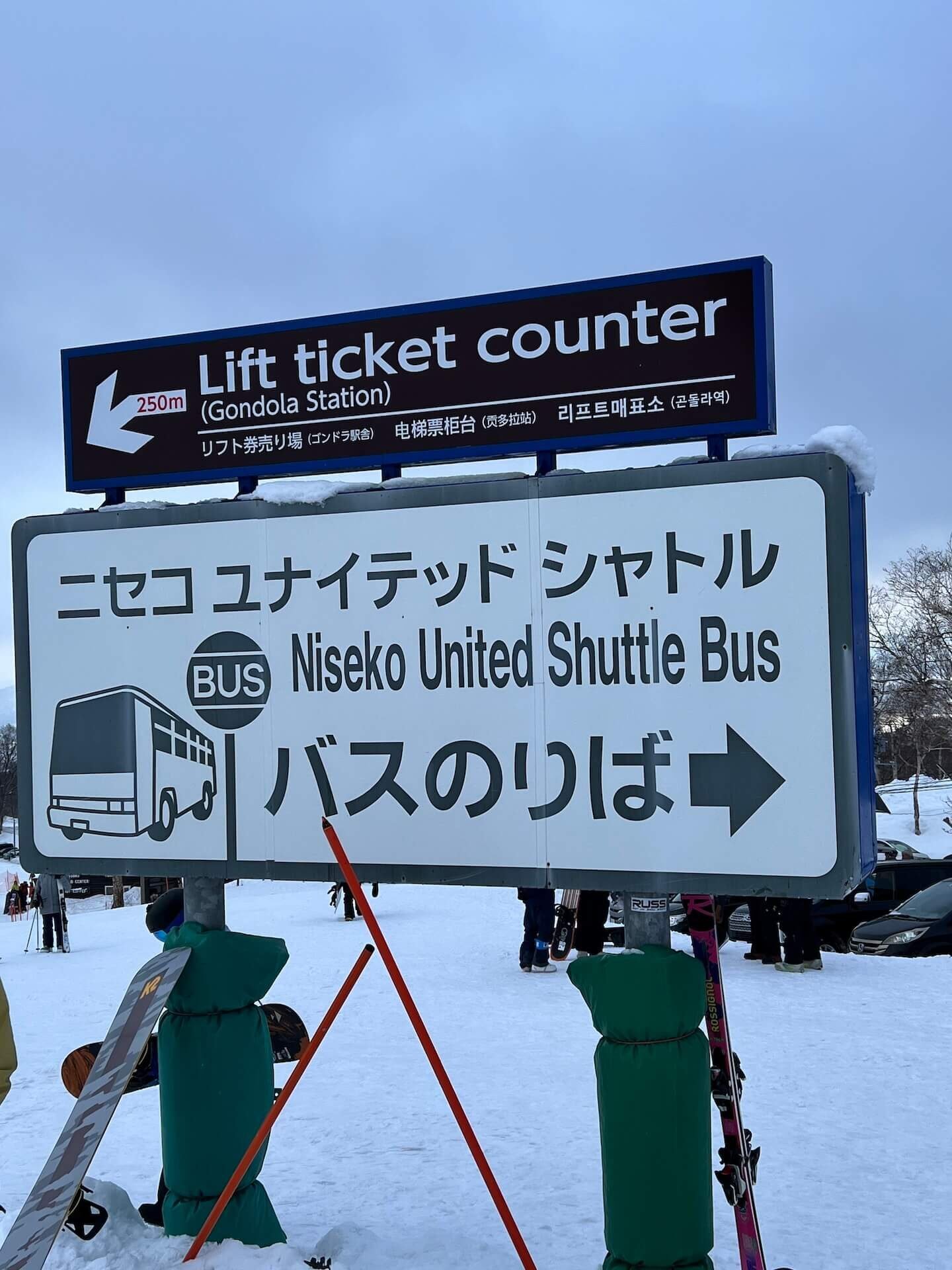 Niseko United shuttle bus stop near the Annupuri base area with skiers and snowboarders waiting in winter conditions