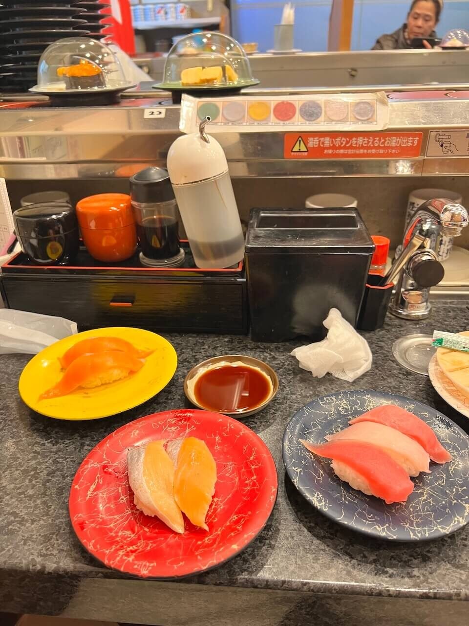 Plates of sushi at a conveyor belt sushi restaurant in Sapporo, an affordable and casual dining option after skiing