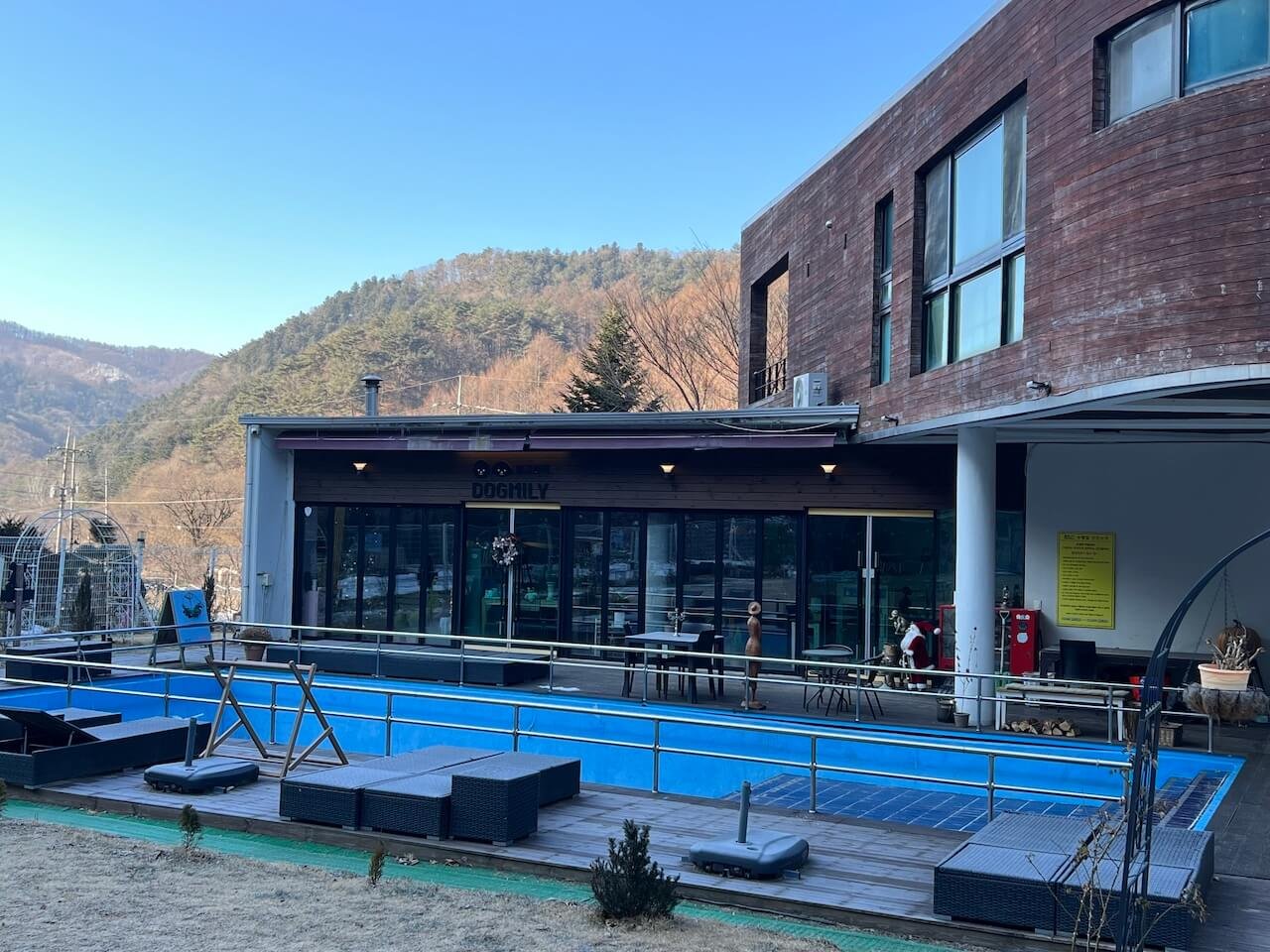 Exterior of DogMily, a dog-friendly pension near Welli Hilli, with an outdoor pool used during warmer months
